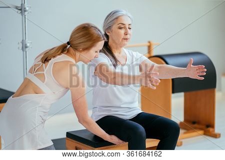 Older Women Doing Pushups. Young Personal Trainer Helping Senior Woman. Workout In Rehabilitation Ce