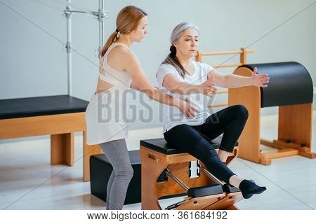 Older Women Doing Pushups. Young Personal Trainer Helping Senior Woman. Workout In Rehabilitation Ce