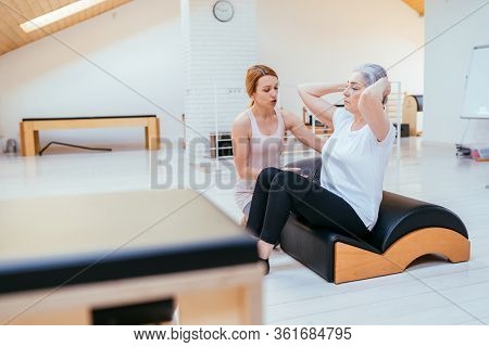 Pilates, Fitness, Sport, Training And People Concept - Woman Doing Exercises On Small Barrel.