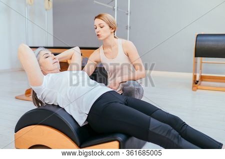 Pilates, Fitness, Sport, Training And People Concept - Woman Doing Exercises On Small Barrel.