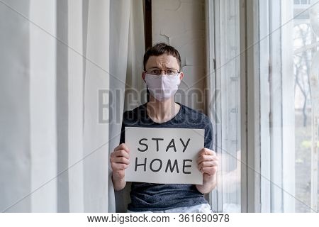 Man Sitting On Windowsill With Nameplate At Selfisolation