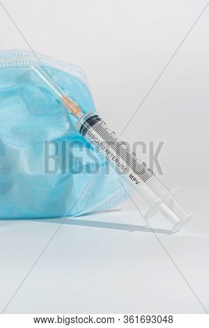 Syringe Injection And Surgical Mask In White Background