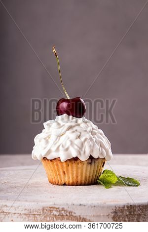 Cupkake With Whipped Cream Decorated With Strawberry On Top On Gray Background.