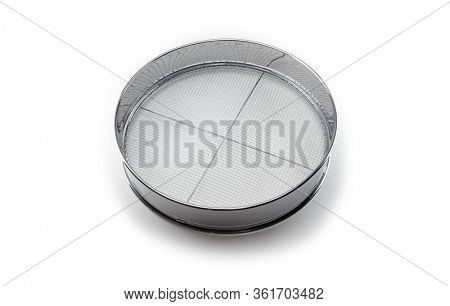 Screening. A chrome sieve or screen used for filtering wanted or unwanted elements.
Also called mesh strainer or sift. Focus at center of screen net.