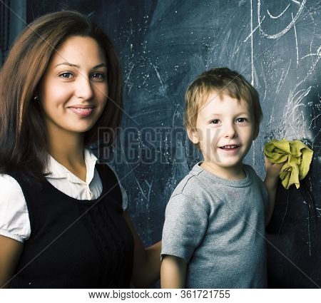 Little Cute Boy In Glasses With Young Real Teacher, Classroom Studying At Blackboard School Kido