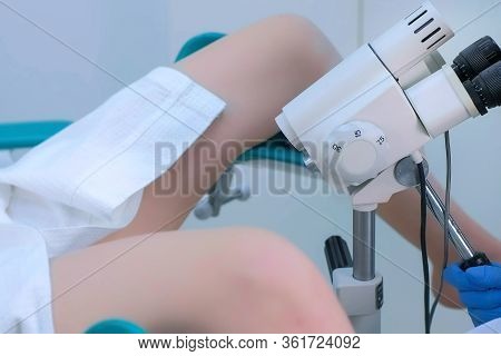 Patient And Doctor In Gynecological Office On Colposcopy Procedure, Side View, Legs Closeup. Doctor 