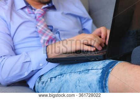 Man Is Working Typing On Laptop At Home Sitting On Couch, Freelance Distant Work On Quarantine, Hand
