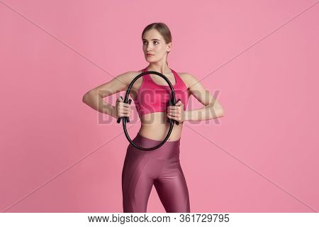 Wellness. Beautiful Young Female Athlete Practicing In Studio, Monochrome Pink Portrait. Sportive Fi