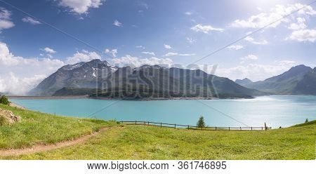 Lake And Meadow By The Mountains In The French Alps.
