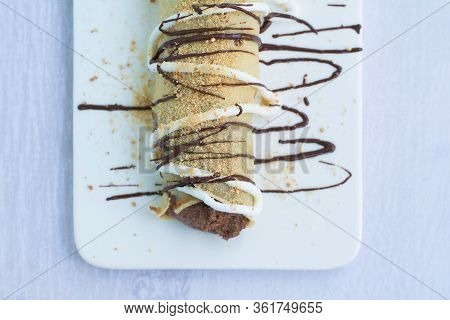 European Pancake Or Palatschinke Or Palacinka With Cocoa And Crumb Crust Filling, Decorated With Cho