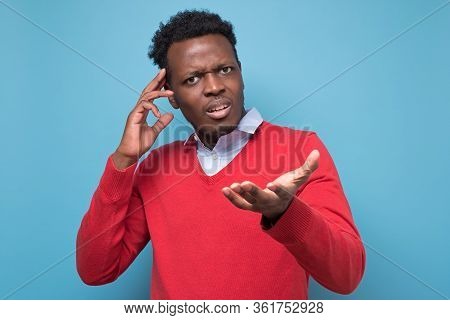 Pensive Young African Man Against A Blue Background