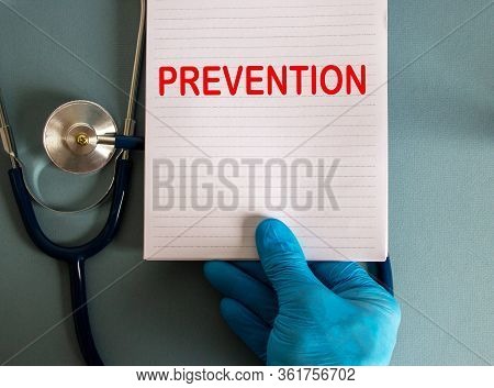 Hand In Blue Glove, White Card With Word Prevention And Stethoscope.