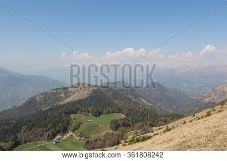 The View Of Rural Contryside In Mountains. Agricultural Fields On Hills With Mountains On Background