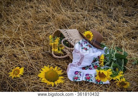 Still Life Of Hats And Baskets With Sunflowers On A Mowed Field