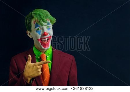 Man In Mime Makeup Cosplay With Green Hair And A Red Suit An Orange Tie And A Green Shirt. Clown Smi