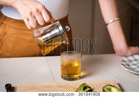 Woman Making Morning Tea To Have With Breakfast At Home