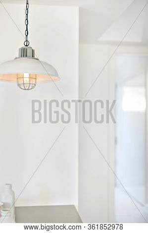 Hanging Lights Illuminating Beside A White Wall In A Modern House