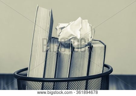 Books And Crumpled Paper In The Bin. Books That Do Not Read, Low-grade Literature_