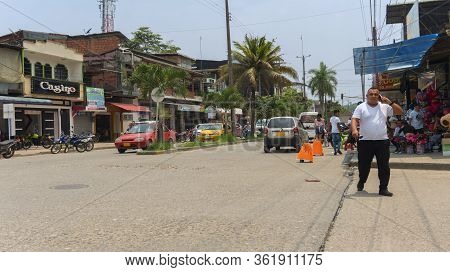 La Hormiga, Putumayo / Colombia - March 8 2020: Man Talking On Cell Phone While Walking Down A Busy 
