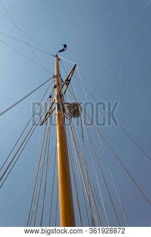 Single Ships Mast With Rigging, Navigation Equipment Against A Clear Blue Sky, Vertical Aspect