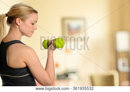 Young beautiful woman workingout inside her livingroom at home