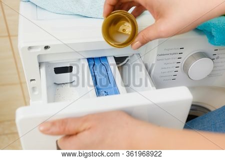 Liquid Powder Detergent And Measuring Cup Pouring Into Machine. Household Duties, Clothes Laundry Ob