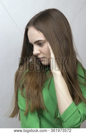 Young Romantic Girl With Long Blond Hair In A Green Dress Is Sad In Melancholy. Profile Girl.