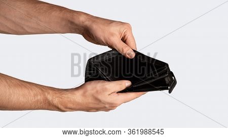 Coronacrisis And Bankruptcy Concept. Closeup Of Businessman Holding Empty Wallet On White Background
