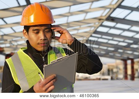 Costruzione ingegnere parlando cellulare sotto nuova costruzione
