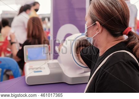 Fat Asia Senior Woman Inserted Her Hand Into The Blood Pressure Monitor. Healthcare And Madical Chec