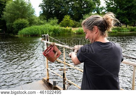 Haerst, Overijssel, The Netherlands, 07 25 2022 - White Strong Woman Operating Manual Ferry Over The