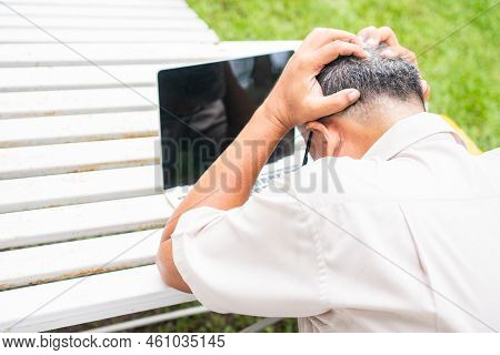 Portrait Of An Old Elderly Asian Man Holds The Head With His Hand Cause Of Stress After Try To Use A