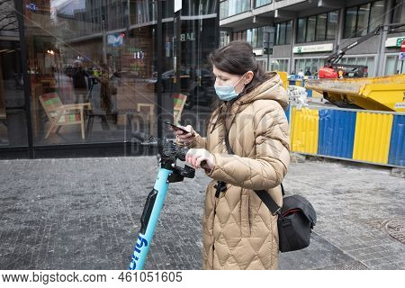 Brussels Belgium - 01.31.2022 A Young Woman In A Warm Down Jacket And A Mask