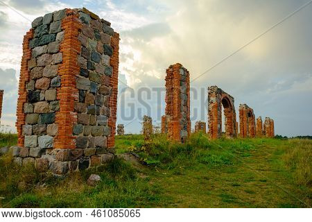 The Remains Of A Stone Column From An Old Building In The Middle Of A Field On A Sunny Spring Day. C