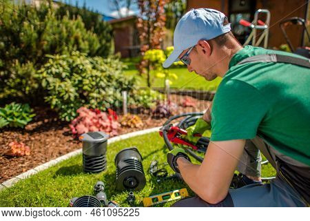 Professional Middle Aged Caucasian Gardener Working On Irrigation System Installation In His Client'
