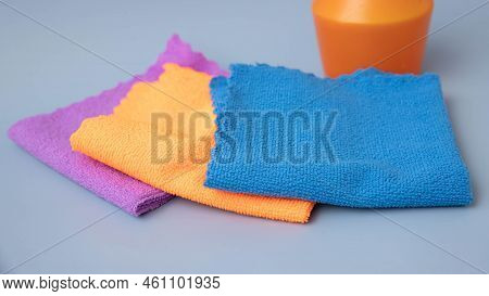 On A Blue Background, There Are Microfiber Cleaning Cloths Of Different Colors Laid Out On The Back 