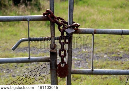 Rusting Padlocks And Chain On A Tubular Steel Farm Field Gate