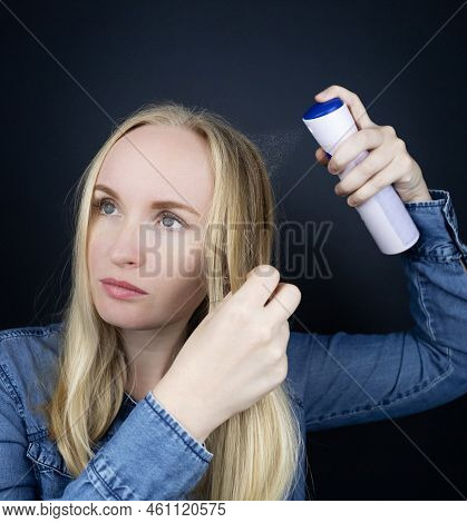 Dry Shampoo. Blonde Girl Sprays Shampoo On Her Hair. The Problem Of Oily Hair While Traveling. An Em