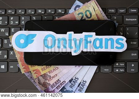 Ternopil, Ukraine - September 6, 2022 Onlyfans Paper Logotype On Bunch Of Brazilian Reals Bills Lies