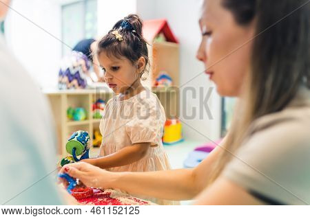 Relaxing Sensory Play With Moldable Kinetic Sand At Nursery School. Toddlers With Their Teacher Havi