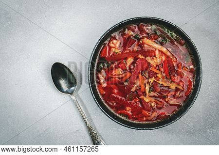 Summer Vegetable Soup With  Cabbage, Beets, And Herbs. Russian Borscht In Plate On Grey Kitchen Tabl