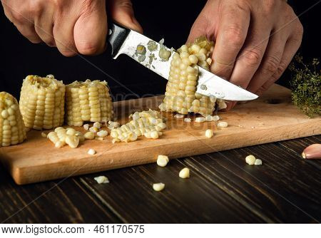 The Cook Cuts The Grains Of Boiled Corn With A Knife. Maize Is An Excellent Dietary Breakfast Or Lun