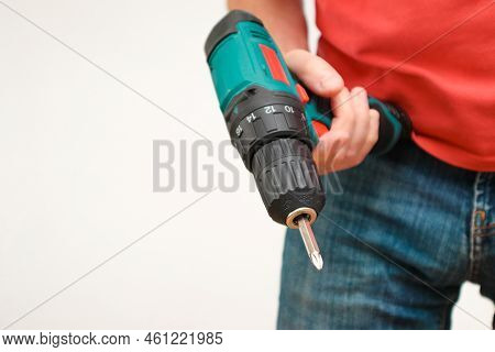 Hand Holding Cordless Drill. Handyman With A Tool Screwdriwer Drill. Electrician With Drill. Worker 