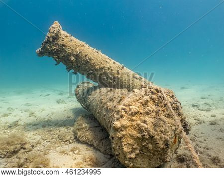 Antique Cannons On A Sandy Sea Floor. Beautiful Turquoise Water In The Background