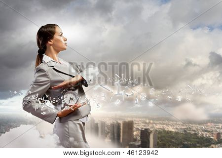 Immagine di giovane imprenditrice holding alarmclock contro illustrazione