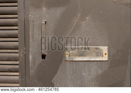 Closeup Of A Rusty Entrance Steel Door With Iron Shiny Silver Mail Slot As Concept For Mailings
