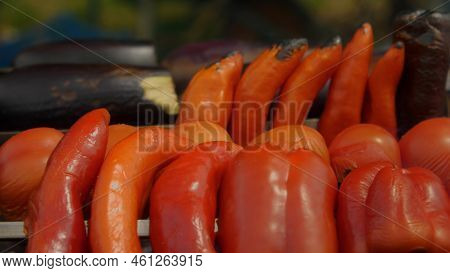 Closeup Of Red Peppers, Bell Peppers And Eggplant On The Charcoal Grill. Smoke Is Going Through The 