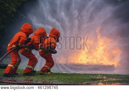 Firefighter Rescue Team Training In Fire Fighting Extinguisher. Firefighter Teamwork Fighting With F