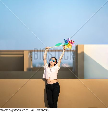 Asian Woman Posts And Play Windmill Toy Colourful Rainbow Colour On The Building Rooftop In Sunset T