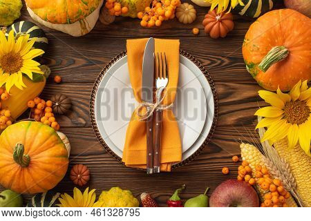 Thanksgiving Day Concept. Top View Photo Of Table Setting Plate Knife Fork Napkin Raw Vegetables Pum
